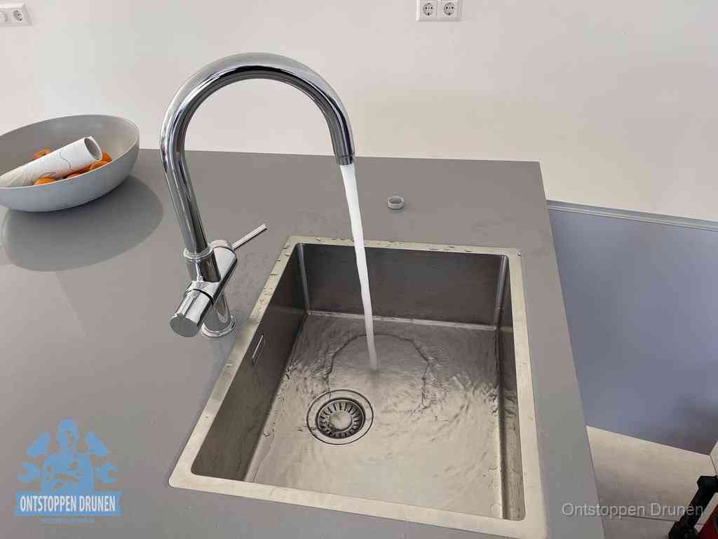 Een vrij doorstromende rvs spoelbak waar het water moeiteloos wegloopt, het resultaat van slim onderhoud dat geld bespaart in Drunen