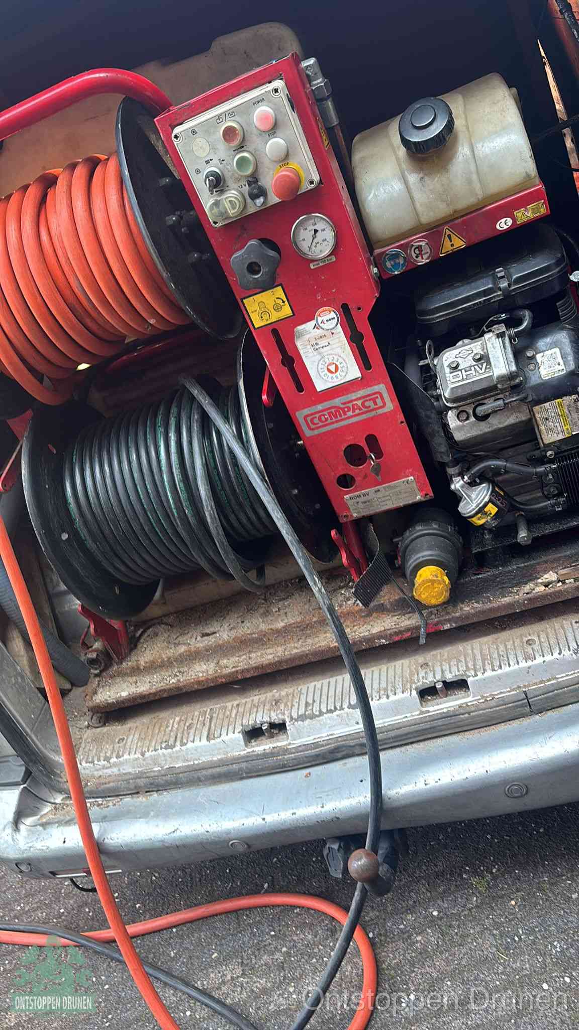 Een rood hogedruk-rioolreinigingstoestel in de laadbak van de bedrijfsbus, apparatuur voor een hardnekkige afvoerverstopping in Drunen