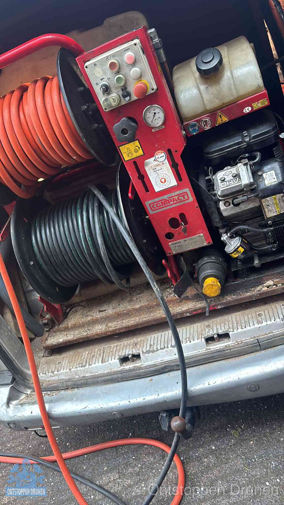 Een rood hogedruk-rioolreinigingstoestel met slangen in de laadbak van de bedrijfsbus, apparatuur voor een hardnekkige wc-verstopping in Drunen