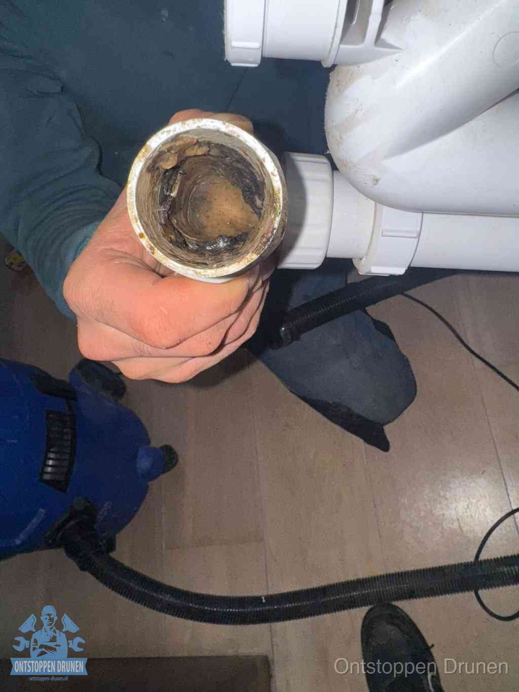 Een losgekoppelde afvoerbuis die van binnen volledig is dichtgeslibd met vet en aanslag, de meest voorkomende oorzaak van een verstopte gootsteen in Drunen