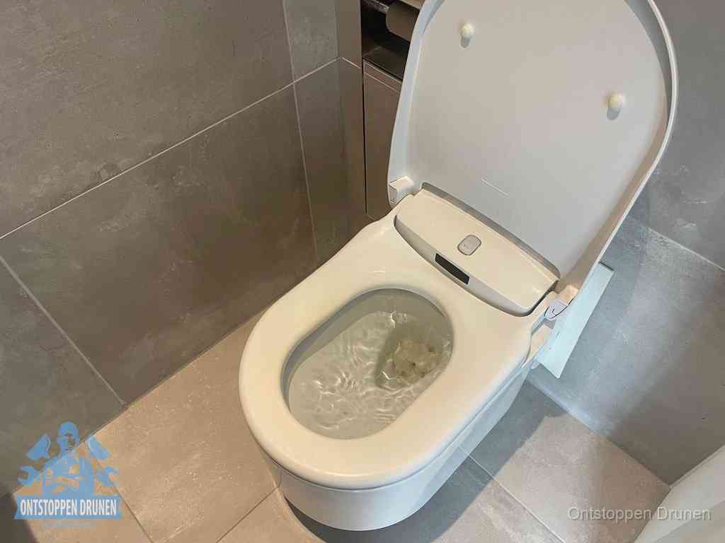Een toiletpot vol troebel water met drijvend papier en restanten, de meest voorkomende oorzaak van een verstopte wc in Drunen
